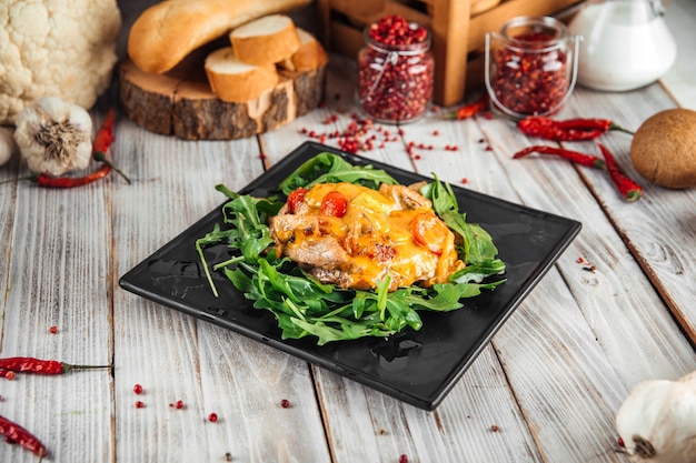 Vue latérale sur julienne sous le fromage à la roquette sur la table en bois