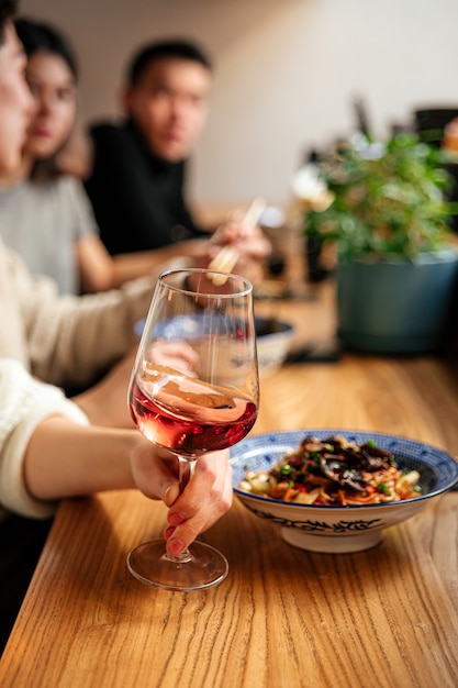 Vue latérale sur main tenant un verre de vin de cocktail apérole