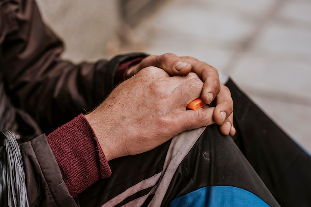 Photo vue latérale des mains de l'homme sans-abri