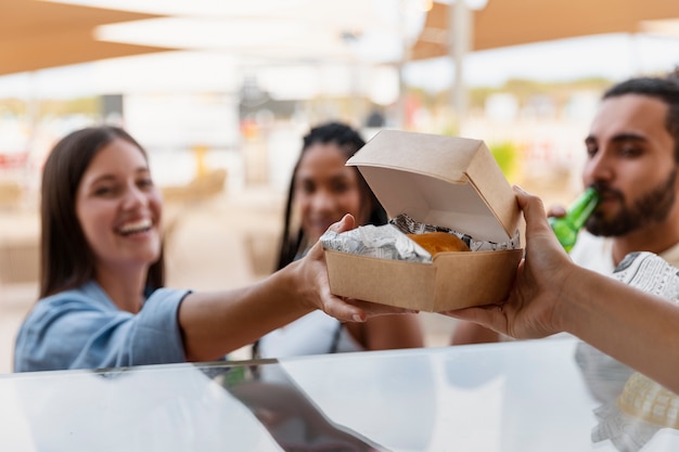 Photo vue latérale mains tenant un récipient alimentaire