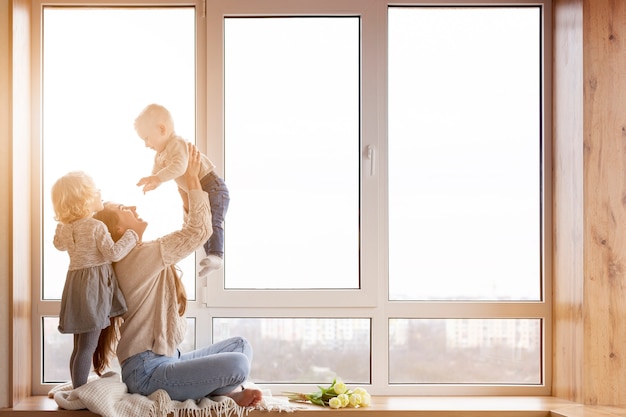 Vue latérale maman jouant avec des enfants