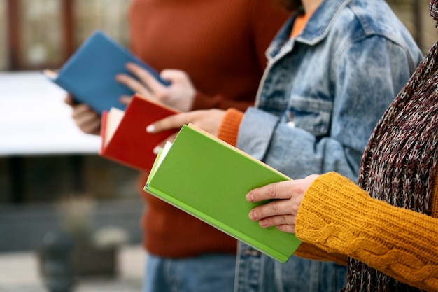 Vue latérale des personnes tenant des livres colorés