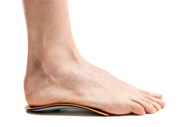 vue latérale des pieds féminins debout sur des semelles orthopédiques. isolé sur fond blanc