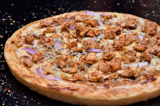 Vue latérale de la pizza avec croûte croustillante de poulet à l'oignon