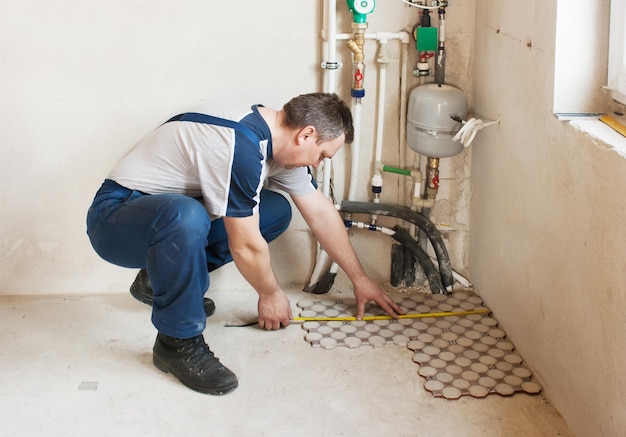 Vue latérale d'un plombier travaillant à la maison