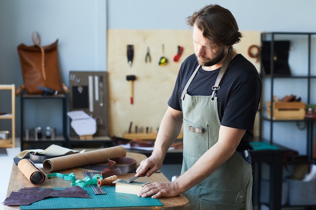 Vue latérale portrait d'un artisan travaillant avec du cuir dans un studio d'atelier concept de petite entreprise co...