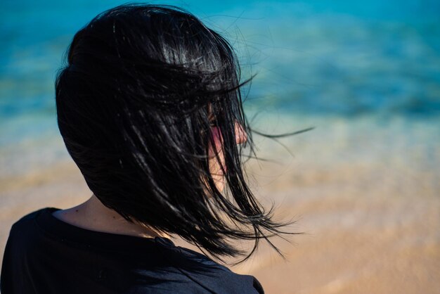 Vue latérale portrait d'une femme relaxante sur la plage