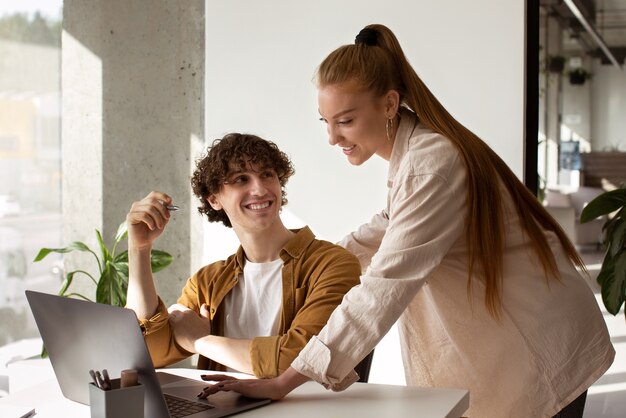 Photo vue latérale smiley homme et femme travaillant