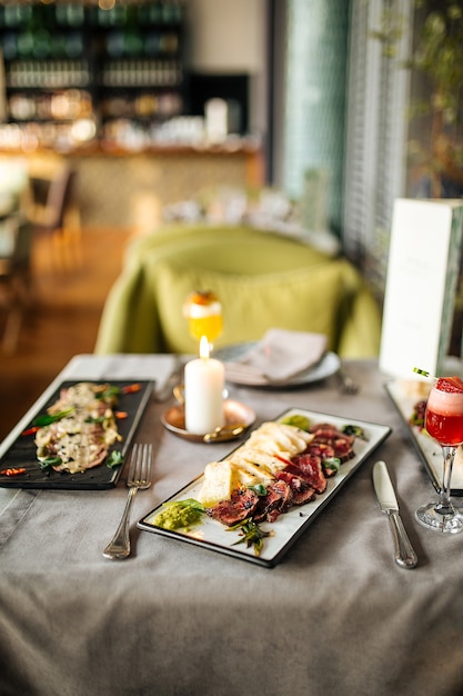 Vue latérale sur la table du restaurant servi avec des apéritifs de cuisine fusion européenne