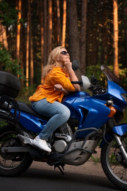 Vue latérale vieille femme cool avec moto