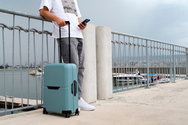 Photo vue latérale voyageur avec une valise