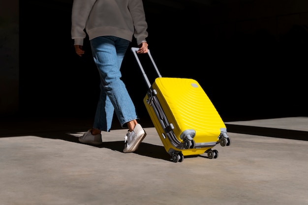 Photo vue latérale voyageur avec une valise