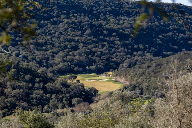 Vue lointaine d'un terrain de golf entre les collines