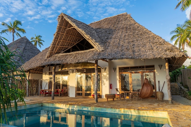 Photo vue matinale d'une villa de luxe sur la plage tropicale près de la mer sur l'île de zanzibar, tanzanie, afrique de l'est