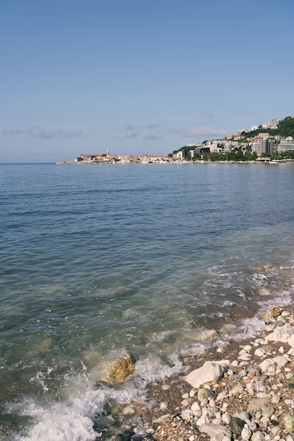 Vue de la mer aux maisons dans les montagnes avec des arbres verts autour