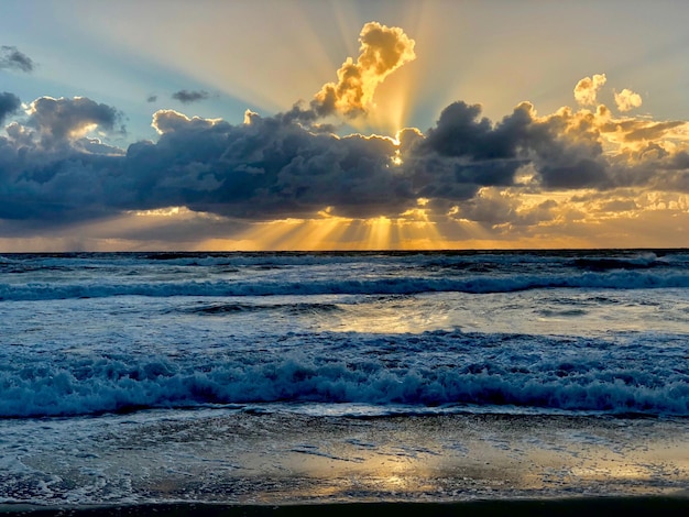 Photo vue de la mer contre un ciel nuageux au coucher du soleil