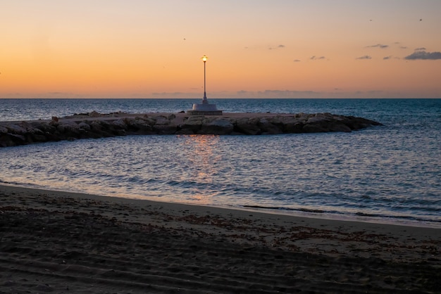 Vue sur la mer et le lampadaire sur la plage de Pedregalejo au crépuscule.