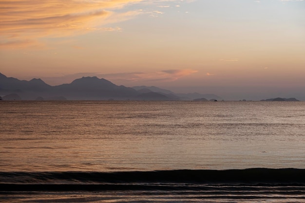 Vue sur la mer et les montagnes au loin à l'aube