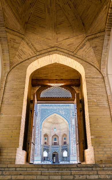 Vue De Mir-i Arab Madrasa à Travers La Porte De La Mosquée Kalyan à Boukhara, Ouzbékistan. Site Du Patrimoine De L'unesco