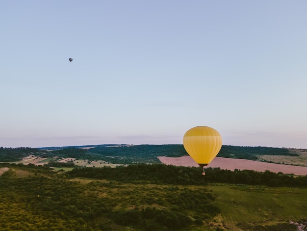 Vue de la montgolfière avec panier vole sur l'espace de copie au coucher du soleil