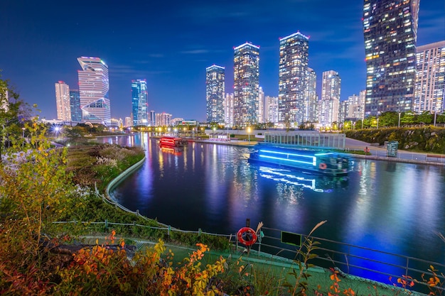 Vue nocturne en automne et bateaux touristiques magnifiquement éclairés au parc central de Songdo dans le district de Songdo Incheon en Corée du Sud