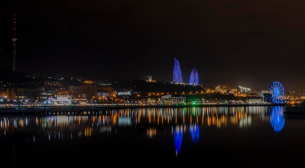 Vue nocturne de Bakou avec la tour de télévision des gratte-ciel et le bord de mer de la mer Caspienne