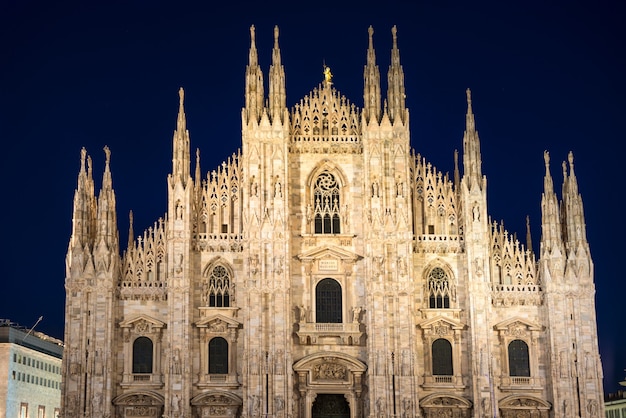 Photo vue nocturne de la célèbre cathédrale de milan (duomo di milano) sur la piazza de milan, italie avec des étoiles sur le ciel bleu foncé