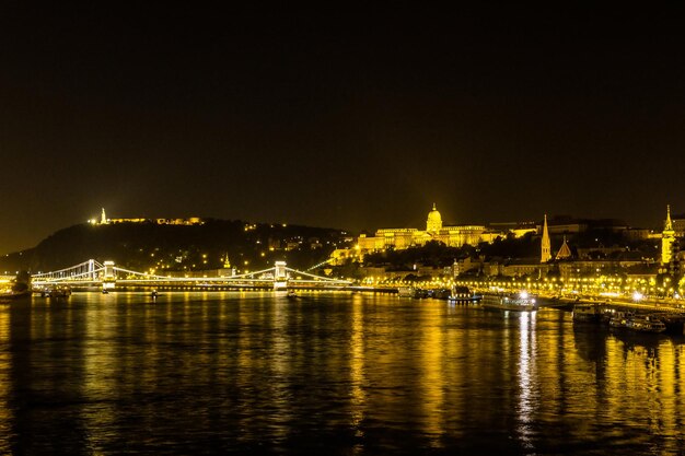 Une vue nocturne depuis le Danube du pont des chaînes et du château de Buda à Budapest