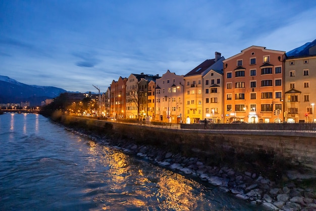 Vue nocturne panoramique de bâtiments colorés en face de la rivière qui coule d'Innsbruck en Autriche