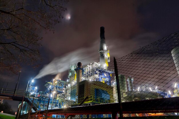 vue nocturne de la raffinerie de pétrole en fumant