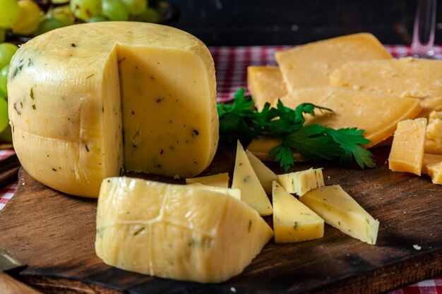 Une vue normale d'un délicieux petit dernier morceau de fromage sur une planche à côté d'un fromage provolone tranché. Concept d'aliments naturels, biologiques et sains.