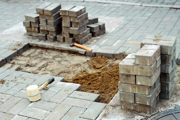 Vue de nouvelles dalles de pavage et de blocs de béton le jour d'été sur le chantier de construction Des blocs de pierre se tiennent dans la pile