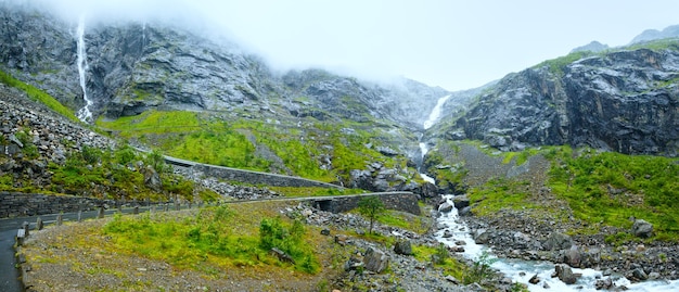 Photo vue nuageuse sur la montagne d'été avec cascade sur la pente de trollstigen (les marches du troll) (norvège).