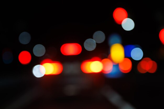 Vue de nuit défocalisée sur la rue du point de vue des conducteurs