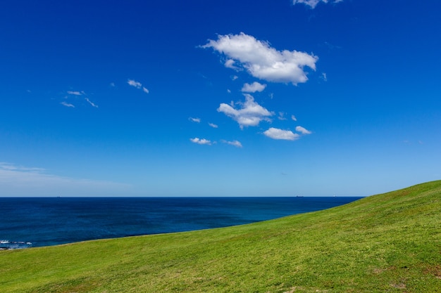 Vue de l&#39;océan et belle colline verte sur les nuages ​​blancs et fond de ciel bleu.