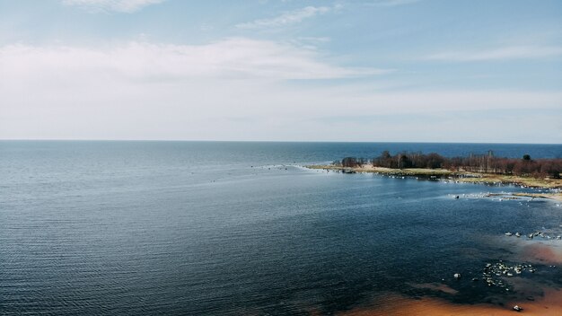 Vue sur l'océan depuis quadcopter, sable et rochers sur la côte de la mer. Vue de dessus de la rive de l'océan. Horizon et eau bleue.