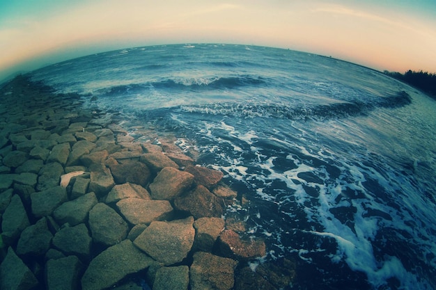 Photo vue à l'œil de poisson de groyne par la mer contre le ciel