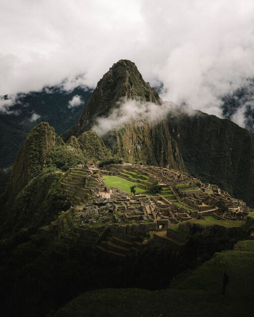 Photo vue d'oiseau de l'ancienne citadelle de machu picchu avec une vue sur les montagnes boisées et le ciel clair