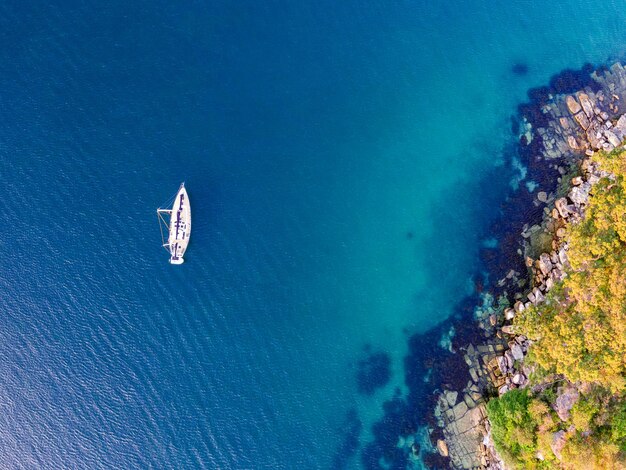 Photo vue d'oiseau d'un yacht à voile ancré à la plage de la boutique près de la station de quarantaine à manly sydney