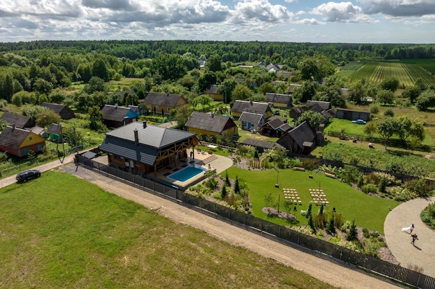 Vue panoramique aérienne sur une maison écologique en bois ou une ferme dans un village verdoyant