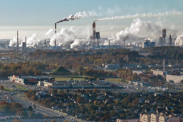 Vue panoramique d'Ariel sur la ville avec une immense usine avec des cheminées fumantes en arrière-plan