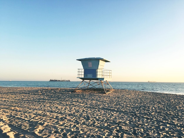 Vue panoramique de la cabane de sauveteur sur la plage contre un ciel dégagé