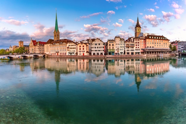 Vue panoramique de la célèbre église fraumunster st peter et de la rivière limmat au lever du soleil dans la vieille ville de zuri...