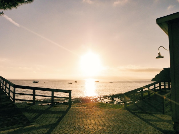 Vue panoramique de la côte et de la mer contre le ciel au coucher du soleil
