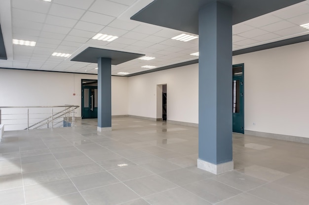 Vue panoramique dans une salle moderne vide avec des portes à colonnes et des fenêtres panoramiques