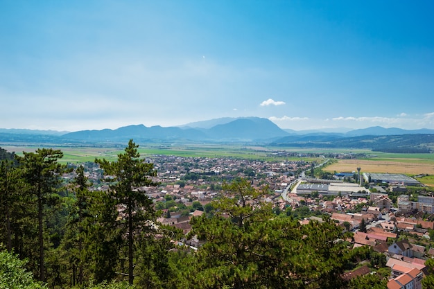 Vue panoramique depuis le sommet de la citadelle de Rasnov, Cetatea Rasnov, sur la ville et les montagnes des Carpates roumaines au loin par une journée ensoleillée d'été. Pays de Brasov, Transylvanie, Roumanie