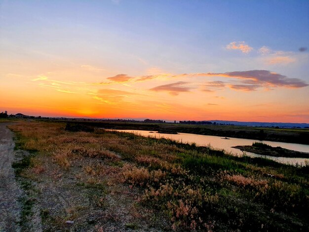 Vue panoramique du champ contre le ciel au coucher du soleil