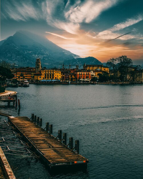 Photo vue panoramique du lac par les bâtiments contre le ciel au coucher du soleil