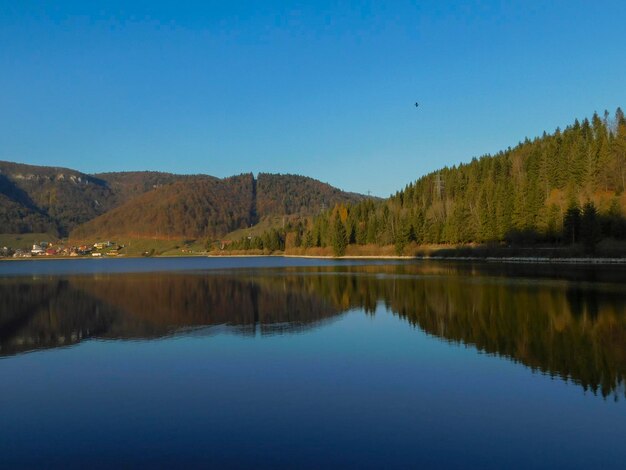 Photo vue panoramique du lac par les montagnes contre un ciel bleu clair