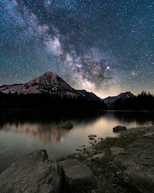 Vue panoramique du lac par les montagnes contre le ciel de nuit